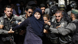 TOPSHOTS Israeli security forces arrest a Palestinian woman during clashes between Palestinian protesters and Israeli police after authorities limited access for Muslim worshipers to the flashpoint al-Aqsa mosque compound in the old city of Jerusalem on July 26, 2015. Israeli police entered the compound, one of Islam's holiest places, to tackle suspected Palestinian rioters, police said. AFP PHOTO / AHMAD GHARABLI