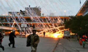 Palestinian civilians and medics run to safety during an Israeli strike over a UN school in Beit Lahia, northern Gaza Strip early on January 17, 2009. A woman and a child were killed early today in the Israeli strike on the UN-run school in northern Gaza where civilians were sheltering from the fighting, medics and witnesses said. Fierce clashes were underway around the school as Israeli tanks exchanged fire with Palestinian militants, they said. AFP PHOTO / MOHAMMED ABED (Photo credit should read MOHAMMED ABED/AFP/Getty Images)