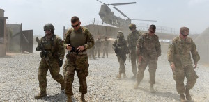 TO GO WITH AFGHANISTAN-US-ARMY-CONFLICT-FOCUS BY GUILLAUME DECAMME In this photograph taken on August 13, 2015, US army soldiers walk as a NATO helicopter flies overhead at coalition force Forward Operating Base (FOB) Connelly in the Khogyani district in the eastern province of Nangarhar. From his watchtower in insurgency-wracked eastern Afghanistan, US army Specialist Josh Whitten doesn't have much to say about his Afghan colleagues. "They don't come up here anymore, because they used to mess around with our stuff. "Welcome to Forward Operating Base Connelly, where US troops are providing training and tactical advice to the 201st Afghan army corps as they take on the Taliban on the battlefield. AFP PHOTO / Wakil Kohsar (Photo credit should read WAKIL KOHSAR/AFP/Getty Images)