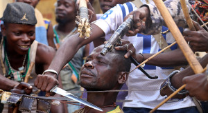 Anti-balaka fighters in the Damala district of Bangui pose, showing off their weapons and methods with one of their members acting as a victim.