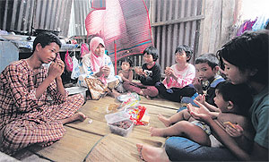 Norehan Kamaruddin bersama anak-anaknya berbuka puasa ala kadar ketika ditemui di sebuah bangsal di Kampung Kurung Tengar, Kuala Perlis, semalam.